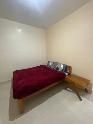 a bed in a room with a red blanket on it at Sky High Villa - Premium Cottages in Ooty