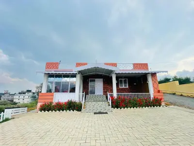 a small building with flowers in front of it at Sky High Villa - Premium Cottages in Ooty