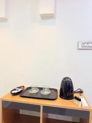 a table with a toaster and two glasses on it at Marhaba plaza in Kozhikode