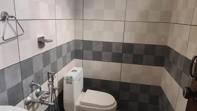 a bathroom with a toilet and a sink at Homey Residency vythiri in Padinjarathara