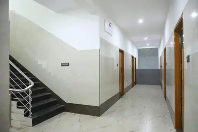 a hallway with a staircase in a building at Viruksham Residency in Palani