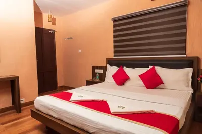 a bedroom with a large bed with red pillows at treevillawayanad in Vythiri