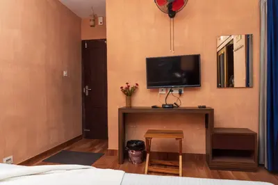 a bedroom with a tv and a table with a stool at treevillawayanad in Vythiri