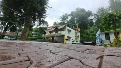a house on the side of a street at The Alpine Inn in Gūdalūr