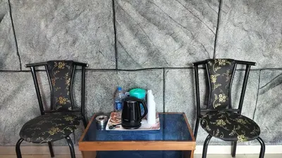 two chairs with a table with a coffee maker on it at Achus Holidays in Munnar