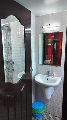 a bathroom with a sink and a toilet and a shower at Achus Holidays in Munnar