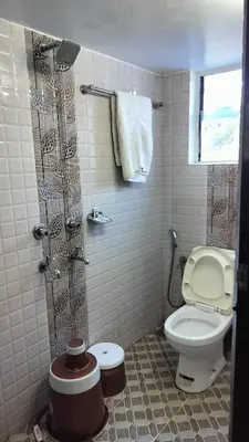 a bathroom with a toilet and a shower at Achus Holidays in Munnar