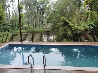 a swimming pool with tongs in the middle at Cozy 3 BHK PoolVilla near Nagerhole National park. in Wayanad