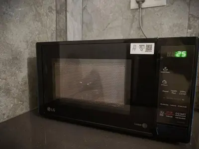 a microwave oven sitting on top of a table at Cozy 3 BHK PoolVilla near Nagerhole National park. in Wayanad