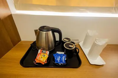 a tea kettle on a tray on a table at HOTEL VARDHA Inn in Bhavāni