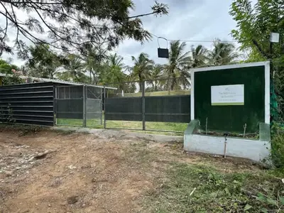 a fence with a sign in front of a field at The Wild Farms By Gwestai in Masinagudi
