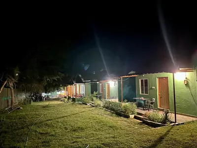 a row of tiny houses at night at The Wild Farms By Gwestai in Masinagudi
