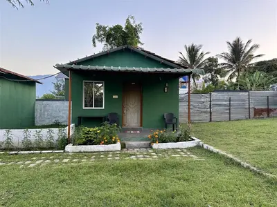a green house with a door in a yard at The Wild Farms By Gwestai in Masinagudi