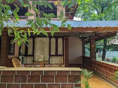 a patio of a house with chairs and a table at Neelambari Ecotoursm in Trichūr