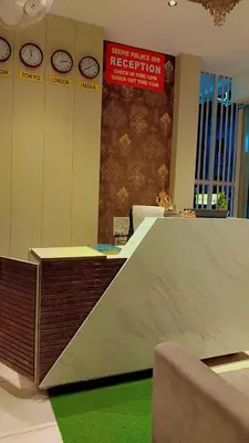 a room with clocks on the wall and a desk at Seema Palace Inn 1 km from Railwaystaion in Mysore