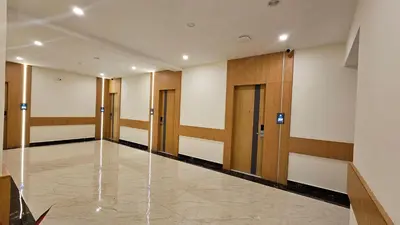 a hallway of a building with wooden doors at Emerald Urban Comforts in Mysore