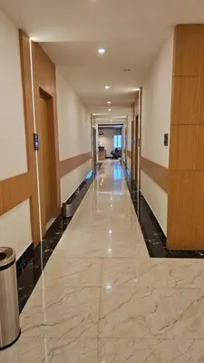 an empty hallway in a building with glass walls at Emerald Urban Comforts in Mysore