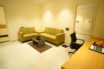 a living room with two yellow couches and a chair at Emerald Urban Comforts in Mysore