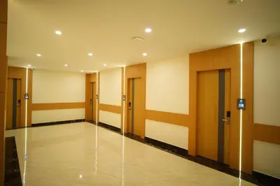 a hallway of an office building with wooden doors at Emerald Urban Comforts in Mysore