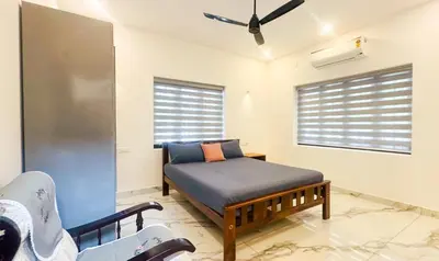 a living room with a bed and a couch at Elegant RiverView Villa in Cochin