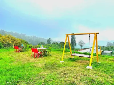 a playground with tables and chairs and a swing at VERMONT HOMe STAY in Ooty
