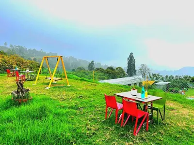 a table and chairs in a field with a playground at VERMONT HOMe STAY in Ooty