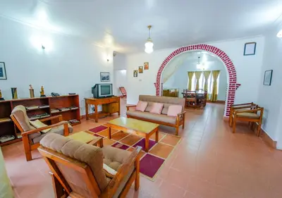 a living room with a couch and a table at Viriparai Tea Bungalow Munnar by VOYE HOMES - Surrounded by Tea Plantations in Munnar