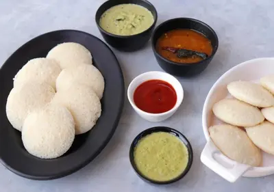 a table with a plate of food with biscuits and dipping sauces at Viriparai Tea Bungalow Munnar by VOYE HOMES - Surrounded by Tea Plantations in Munnar