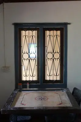a window in a room with a table and chairs at River view cottage in Vythiri