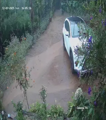 a car is parked on a dirt road at River view cottage in Vythiri
