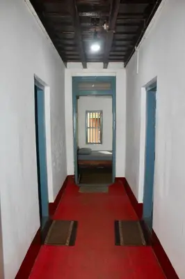 a hallway with a red floor and a red carpet at River view cottage in Vythiri