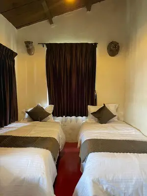 two beds in a room with a window at Sandy Holiday Home 5 Bhk in Ooty