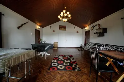 a room with a table and chairs and a chandelier at The Green Casa By Green leaves -Families Only in Ooty