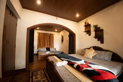 a living room with a bed and a couch at The Green Casa By Green leaves -Families Only in Ooty