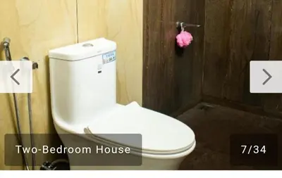 a bathroom with a white toilet in a room at Niks home stay - A in Trichūr