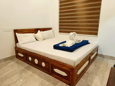 a bed in a room with a towel on it at Paradise Single Room in Wayanad