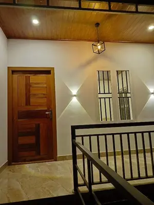 a hallway with a wooden door and a staircase at Paradise Single Room in Wayanad