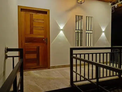 a room with a wooden door and a staircase at Paradise Single Room in Wayanad
