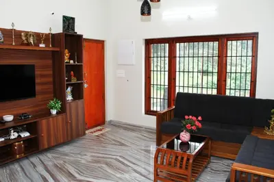 a living room with a couch and a television at Airy Homestay Ooty by Lexstays in Ooty
