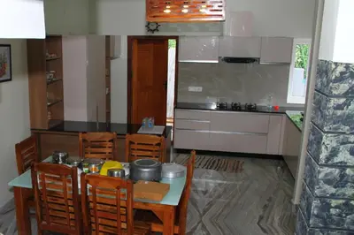 a kitchen with a table and chairs and a counter at Airy Homestay Ooty by Lexstays in Ooty