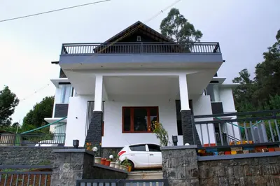 a white house with a car parked in front at Airy Homestay Ooty by Lexstays in Ooty