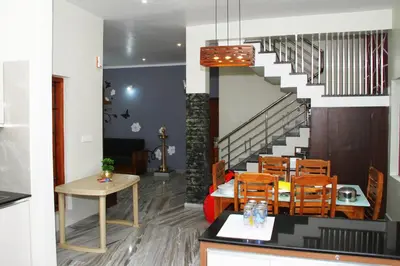 a dining room with a table and a staircase at Airy Homestay Ooty by Lexstays in Ooty
