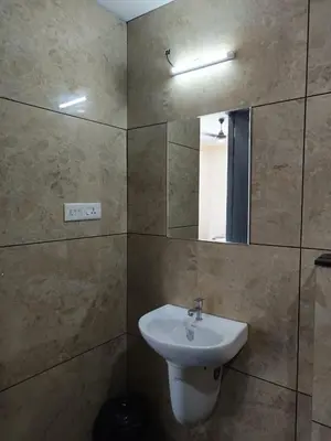 a bathroom with a sink and a mirror at RIVULET HOTEL APARTMENTS in Mukkam