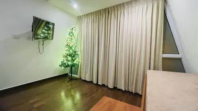 a living room with a television and a plant at The Mallika Holidays - A Cabin in Mananthavady