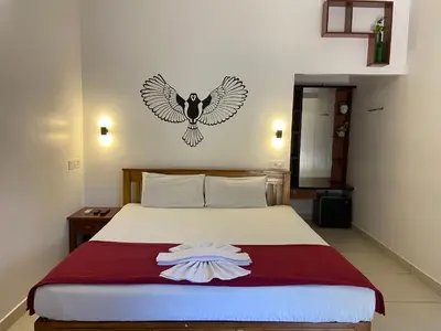 a bedroom with a bed with a bird on the wall at Dove cottage in Cherai Beach