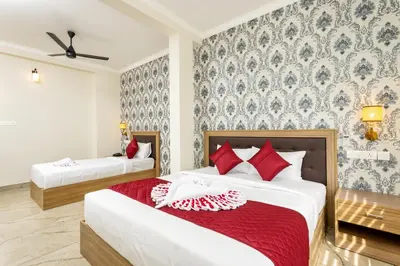 a bedroom with two beds with red pillows at ESAA Airport Hotel in Cochin