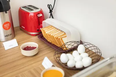 a table with a basket of eggs and a mixer at ESAA Airport Hotel in Cochin