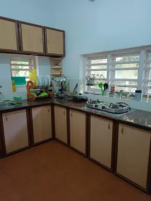 a kitchen with wooden cabinets and a counter top at Raaga on the Beach in Kannur