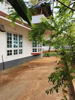 a house with a dirt road in front of it at Raaga on the Beach in Kannur