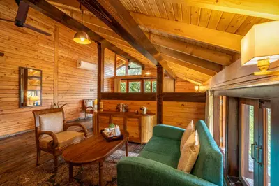 a living room with a green couch and a table at amã Stays and Trails The Malabar Villa Hibiscus, Kozhikode in Puthuppādi
